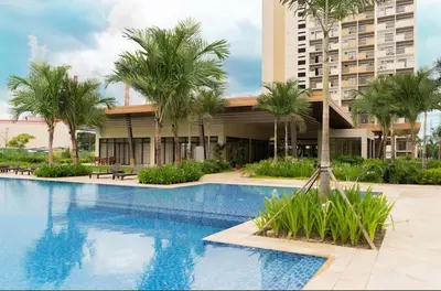 a swimming pool with palm trees in front of a building at Staycation in Brgy Buli in Manila