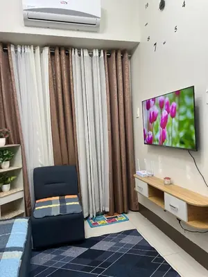 a living room with a tv and a chair at Condotels RQ Hob in Manila