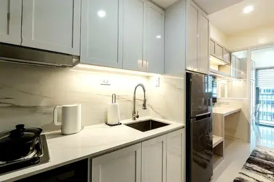 a kitchen with white cabinets and a sink at Hotel Comfort FREE Parking Fame Mall Access in Manila