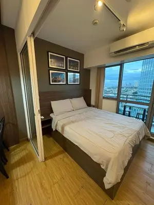 a bedroom with a large bed with a large window at Staycation at Brgy Sucat in Manila