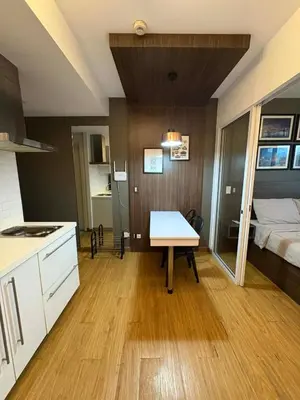 a kitchen and a bedroom with a bed and a table at Staycation at Brgy Sucat in Manila
