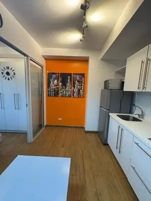 an empty kitchen with an orange door in a room at Staycation at Brgy Sucat in Manila