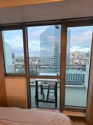 a bedroom with a view of the city from a window at Staycation at Brgy Sucat in Manila