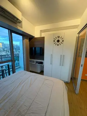 a bedroom with a bed with a clock on the wall at Staycation at Brgy Sucat in Manila
