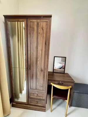 a bedroom with a wooden cabinet and a desk with a mirror at Fame Residence Tower 4 near Greenfield and Shaw MRT in Sampong