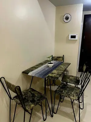 a table and chairs in a room with a clock on the wall at XYz's Condo - Walk To MNL T3 via Runway Manila in Manila
