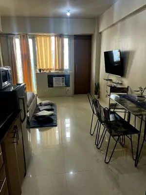 a living room with a table and chairs and a television at XYz's Condo - Walk To MNL T3 via Runway Manila in Manila