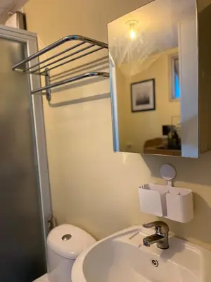 a bathroom with a sink and a toilet and a mirror at Staycation and WFH with Netflix and Pool for up to 4 guests in Manila