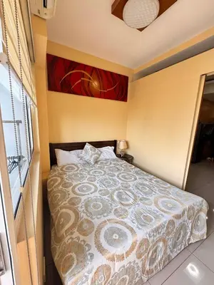 a bedroom with a bed with a comforter at Kitty Breeze Staycation in Manila