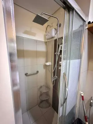 a shower with a glass door in a bathroom at Kitty Breeze Staycation in Manila