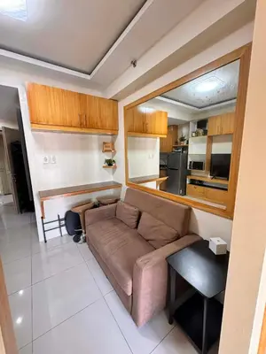 a living room with a couch and a kitchen at Kitty Breeze Staycation in Manila