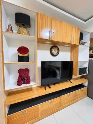 a large entertainment center with a tv in a living room at Kitty Breeze Staycation in Manila