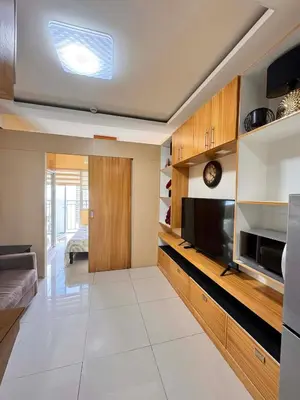 a large living room with a television and a kitchen at Kitty Breeze Staycation in Manila
