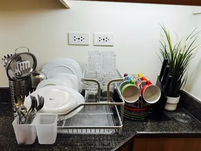 a dish drying rack on a kitchen counter with utensils at The Camden Place Aesthetic Elegant Condo Unit 15 in Manila