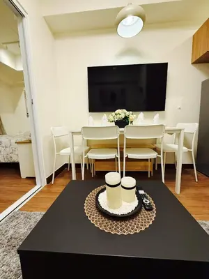 a dining room with a table and chairs and a tv at The Camden Place Aesthetic Elegant Condo Unit 15 in Manila