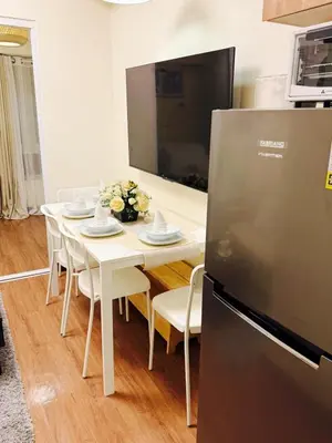 a kitchen with a white table with chairs and a refrigerator at The Camden Place Aesthetic Elegant Condo Unit 15 in Manila