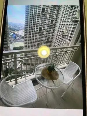 a table and chairs on a balcony with a view of a building at La Mari Staycation 2bedroom at Prisma Residences in Manila