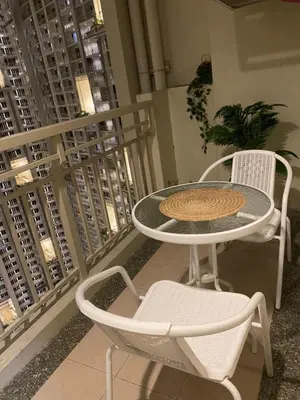 a table and two chairs on a balcony at La Mari Staycation 2bedroom at Prisma Residences in Manila