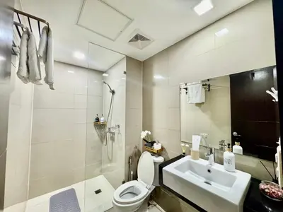 a bathroom with a white toilet and a sink at Cozy Apartment in Venice Luxury Residences BGC in Manila