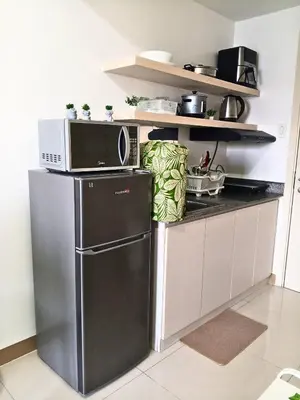 a kitchen with a refrigerator and a microwave at Terra Nueve Escape - 1br with Balcony Staycation in Manila