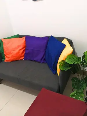 a black couch with colorful pillows on it at Terra Nueve Escape - 1br with Balcony Staycation in Manila