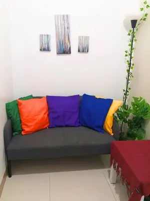a couch with colorful pillows on it in a room at Terra Nueve Escape - 1br with Balcony Staycation in Manila