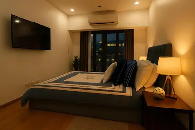 a bedroom with a bed with a television on the wall at New 2BR Suite Milano Residences Poblacion Makati 110sqm in Sampong