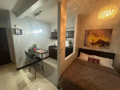 a small apartment with a bed and a desk in a room at Jazzy Flat in Manila