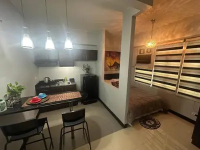 a small kitchen with a table and chairs in a room at Jazzy Flat in Manila