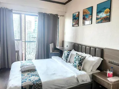 a bedroom with a bed and a large window at Ancalm condon in Manila