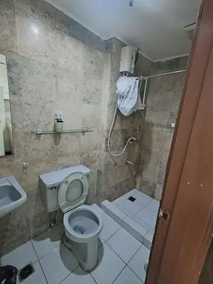 a bathroom with a toilet and a sink and a shower at Ancalm condon in Manila