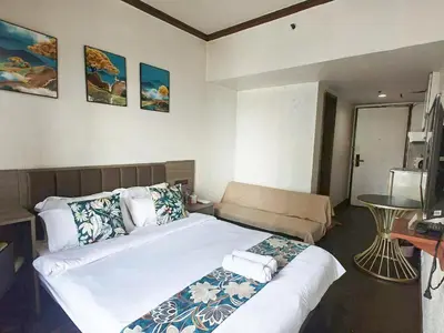a bedroom with a large bed and a couch at Ancalm condon in Manila