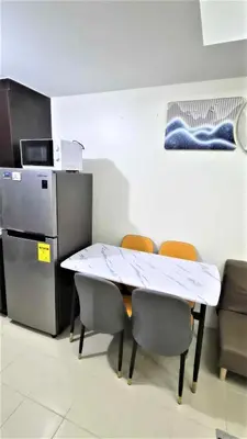 a kitchen with a table and chairs and a refrigerator at City View with Balcony at Kasara Residences C5 Pasig in Manila