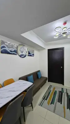 a living room with a couch and a table and chairs at City View with Balcony at Kasara Residences C5 Pasig in Manila