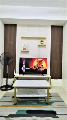 a living room with a tv and a table at City View with Balcony at Kasara Residences C5 Pasig in Manila