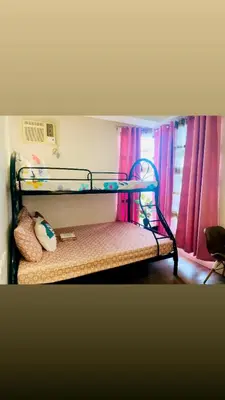 a bunk bed in a room with pink curtains at Hotel hotel in Manila