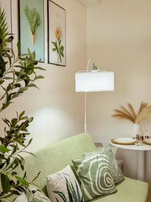 a living room with a green couch and a lamp at Staycation near Mall of Asia in Manila