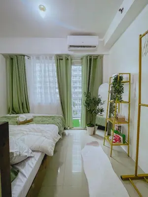 a bedroom with two beds and a window at Staycation near Mall of Asia in Manila