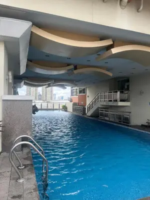 a swimming pool in the middle of a building at JFS Staycation at Birch Tower - Cozy Home in Manila