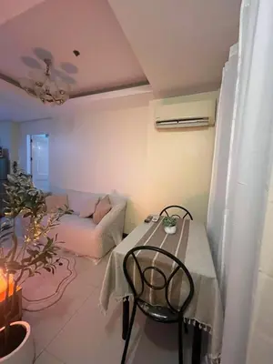 a living room with a table and a couch at JFS Staycation at Birch Tower - Cozy Home in Manila