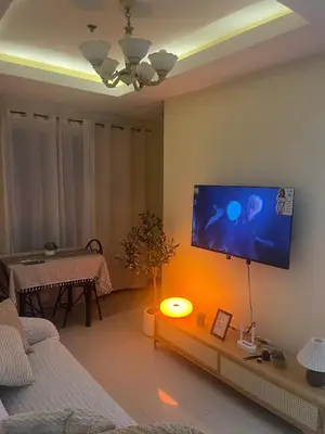 a living room with a flat screen tv on the wall at JFS Staycation at Birch Tower - Cozy Home in Manila