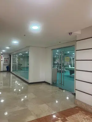 an empty lobby with glass doors in a building at JFS Staycation at Birch Tower - Cozy Home in Manila
