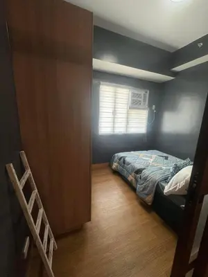 a small bedroom with a bed and a window at Staycation by Purple Tree in Manila