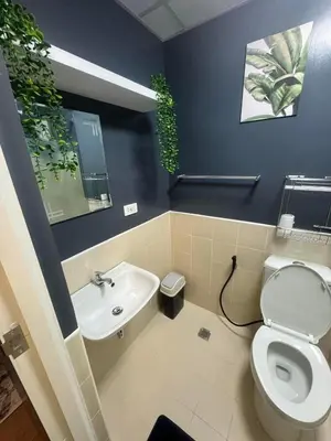 a bathroom with a toilet and a sink at Staycation by Purple Tree in Manila