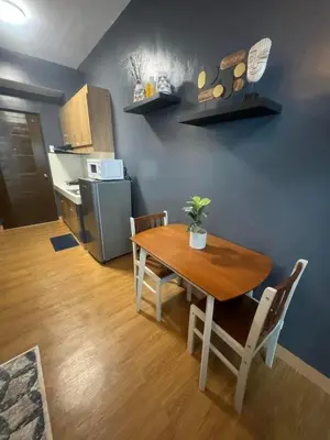 a dining room with a table and a kitchen at Staycation by Purple Tree in Manila