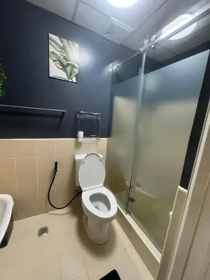 a bathroom with a toilet and a shower at Staycation by Purple Tree in Manila