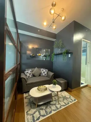 a living room with a couch and a table at Staycation by Purple Tree in Manila