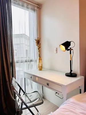 a desk with a lamp and a chair in a bedroom at 81 Newport Urban Chic Studio near NAIA Terminal 3 in Manila