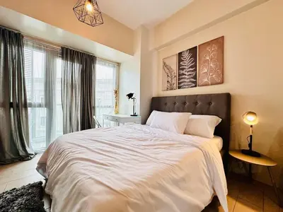 a bedroom with a large bed and a window at 81 Newport Urban Chic Studio near NAIA Terminal 3 in Manila