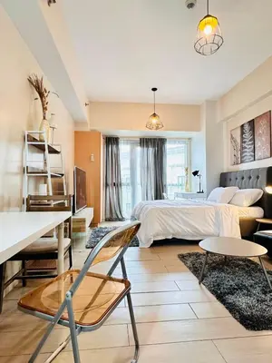 a bedroom with a bed and a table and chairs at 81 Newport Urban Chic Studio near NAIA Terminal 3 in Manila